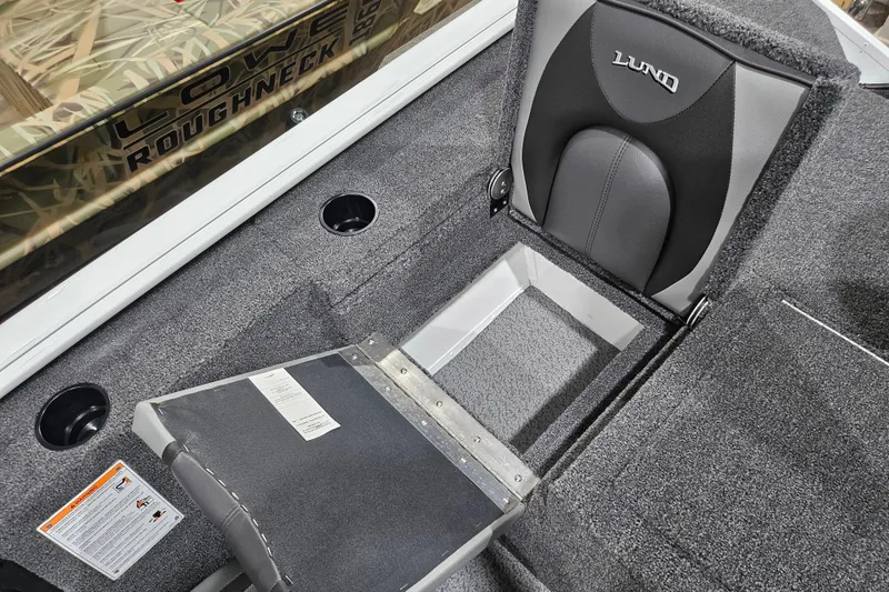 Slide: The Image of 2026 Lund 1875 Renegade boat interior with storage compartment and cushioned seat. - 12