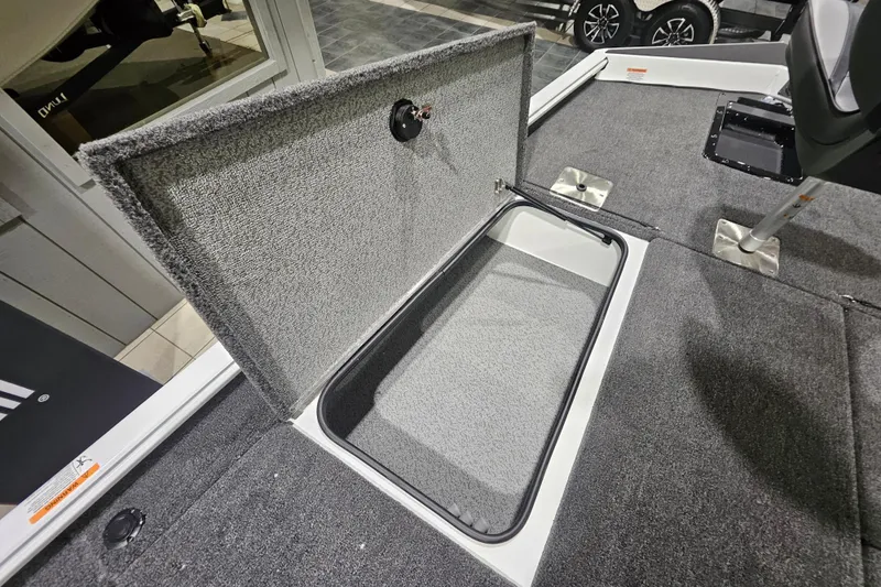 Slide: The Image of Open storage compartment in 2026 Lund 1875 Renegade boat, featuring carpeted interior. - 14