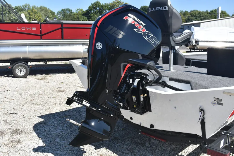 Slide: The Image of 2026 Lund 1875 Renegade boat with Mercury Pro XS outboard motor, parked on gravel. - 6