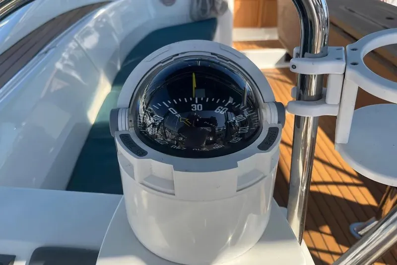Slide: The Image of Compass on Delphia 47 yacht, 2012 model, with wooden deck background. - 21