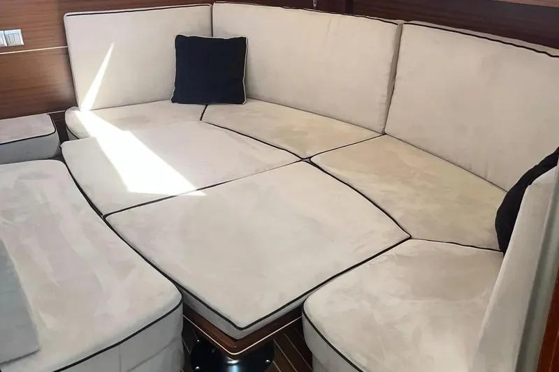 Slide: The Image of Luxurious beige seating area inside a 2012 Delphia 47 yacht, featuring plush cushions. - 37