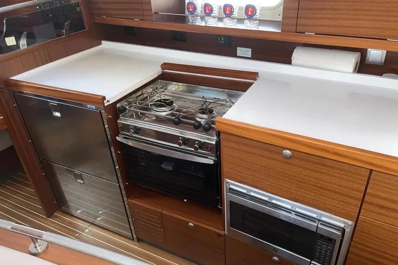 Slide: The Image of Modern kitchen in 2012 Delphia 47 yacht with stove, microwave, and wooden cabinetry. - 42