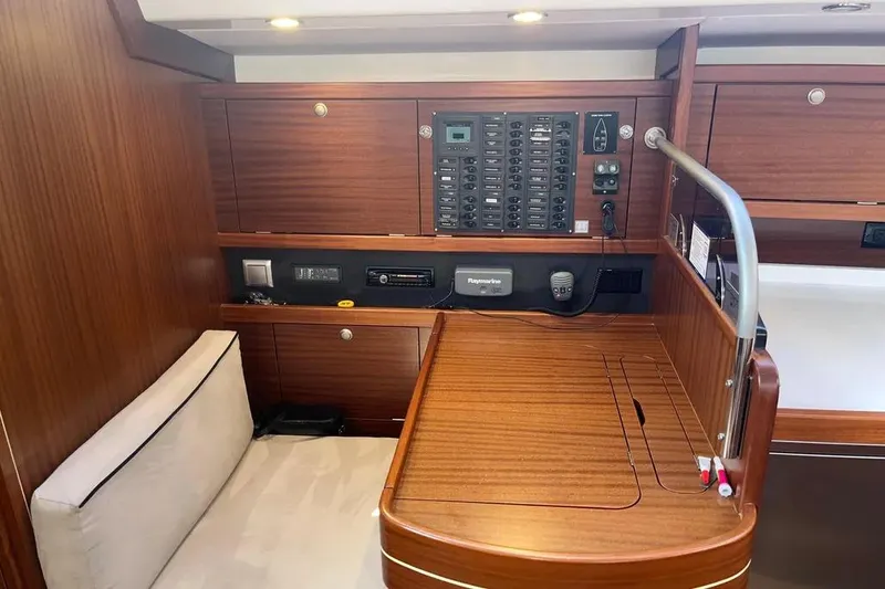 Slide: The Image of Navigation station of 2012 Delphia 47 yacht with control panel and seating area. - 48