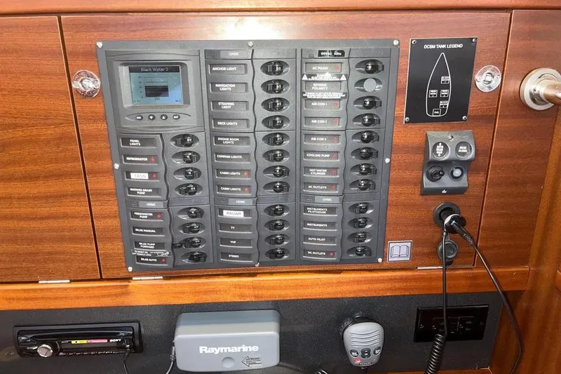 Slide: The Image of Electrical control panel on a 2012 Delphia 47 yacht, featuring switches and Raymarine equipment. - 51