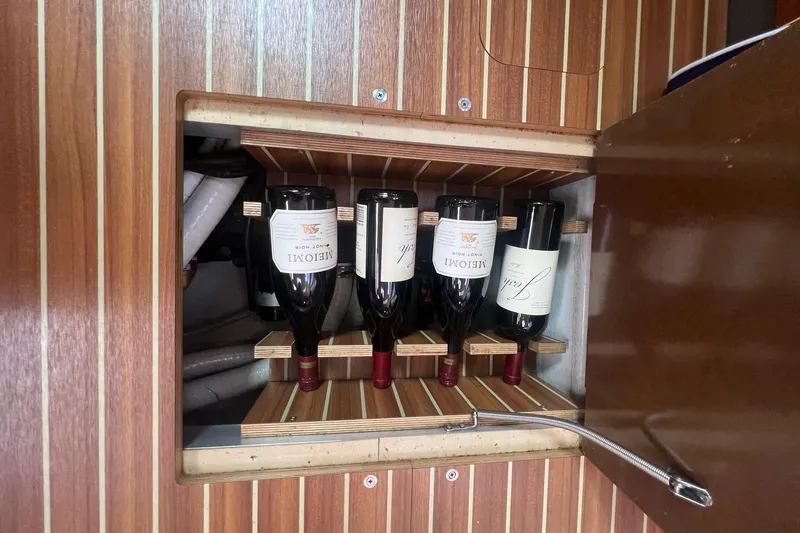 Slide: The Image of Wine bottles stored in a wooden cabinet on a 2012 Delphia 47 yacht. - 59