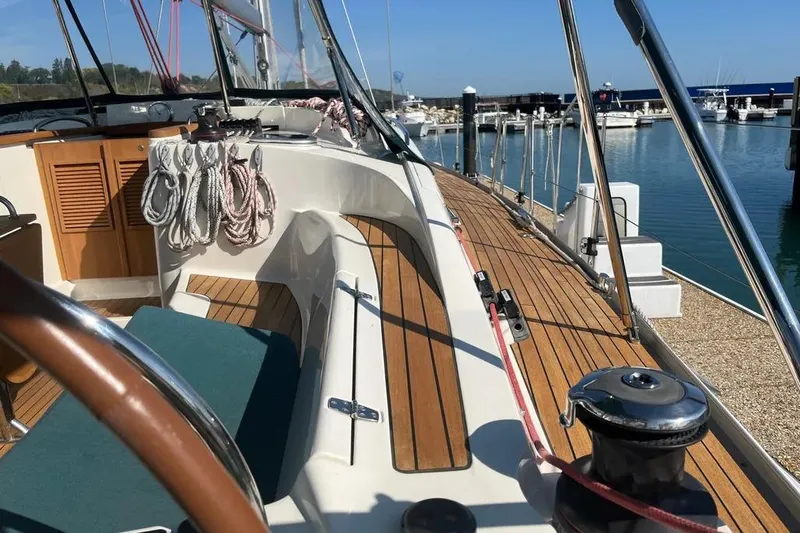 Slide: The Image of Delphia 47 sailboat deck, 2012 model, with wooden finish and marina view. - 6