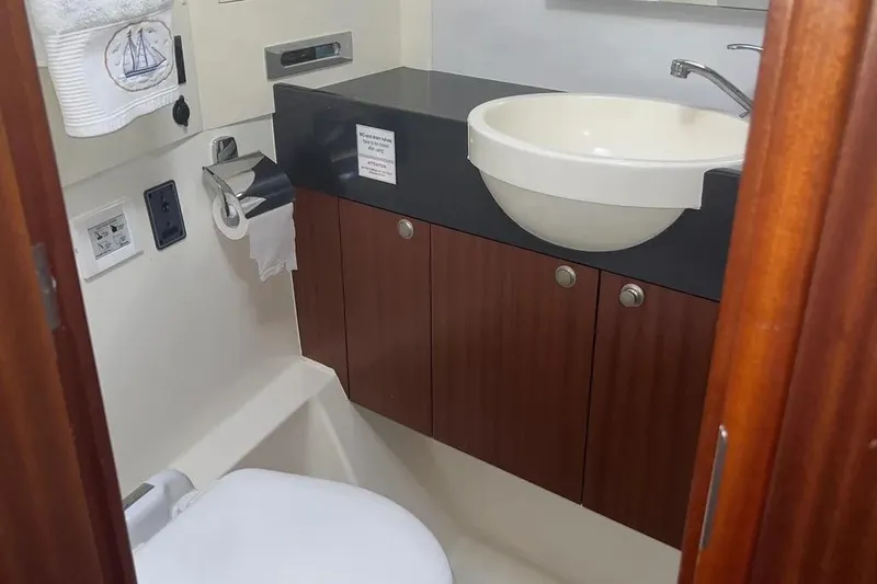 Slide: The Image of Bathroom interior of 2012 Delphia 47 yacht with sink and wooden cabinets. - 76