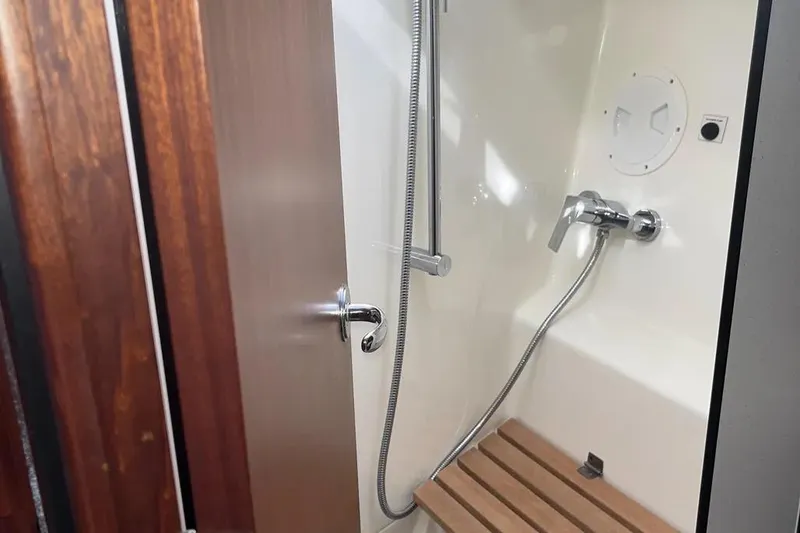Slide: The Image of Shower area in 2012 Delphia 47 yacht with wooden bench and chrome fixtures. - 81