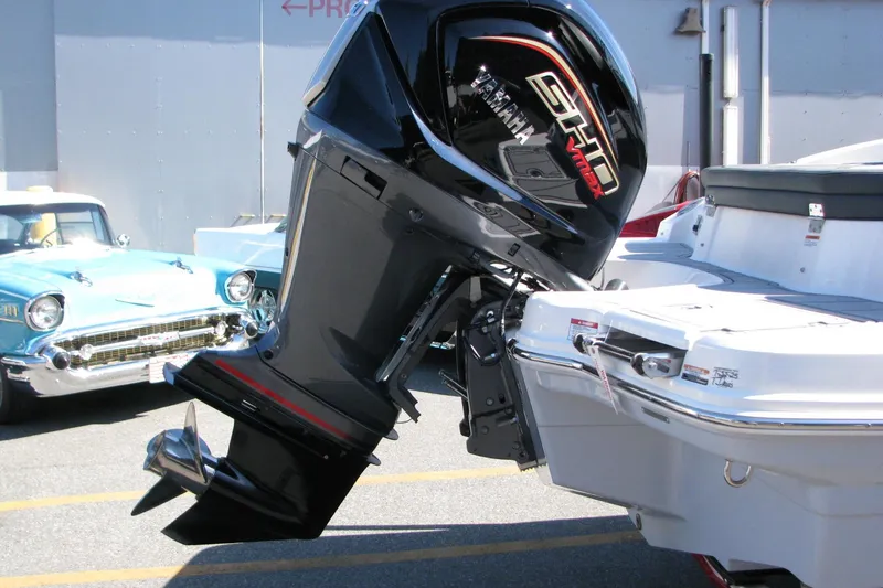 Slide: The Image of 2026 Chaparral 23 SSi OB boat with Yamaha outboard motor, parked near vintage car. - 3
