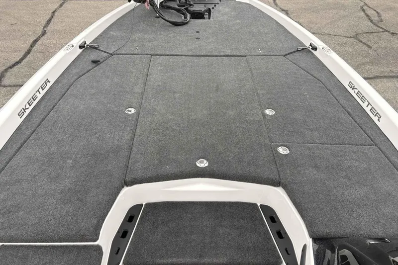 Slide: The Image of 2026 Skeeter ZXE21 boat deck with gray carpeting and storage compartments. - 10