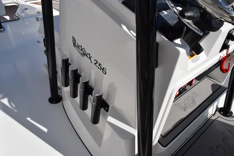 Slide: The Image of 2026 BlackJack 256 Coastal boat interior with rod holders and steering console. - 20