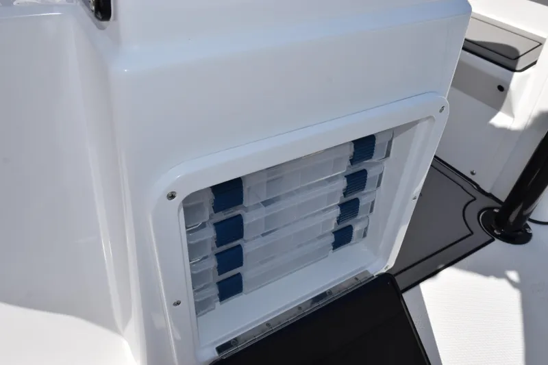 Slide: The Image of Storage compartment on a 2026 BlackJack 256 Coastal boat, featuring organized tackle boxes. - 21