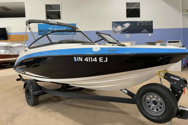 Slide: The Image of 2022 Yamaha Boats SX190 on trailer in showroom, black and blue design. - 2