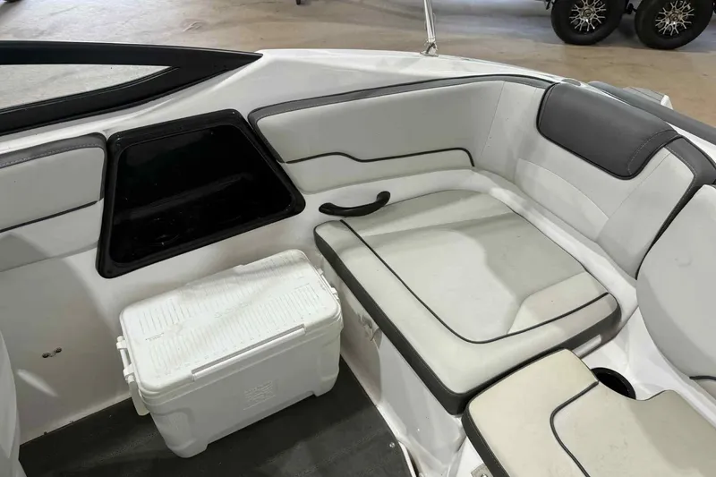 Slide: The Image of 2022 Yamaha Boats SX190 interior with white seating and a cooler. - 20