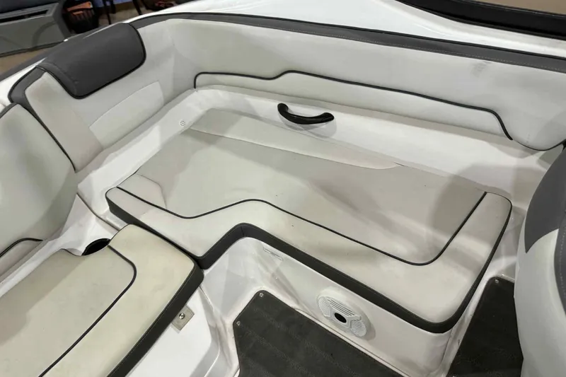 Slide: The Image of 2022 Yamaha Boats SX190 interior seating with white and gray upholstery. - 22