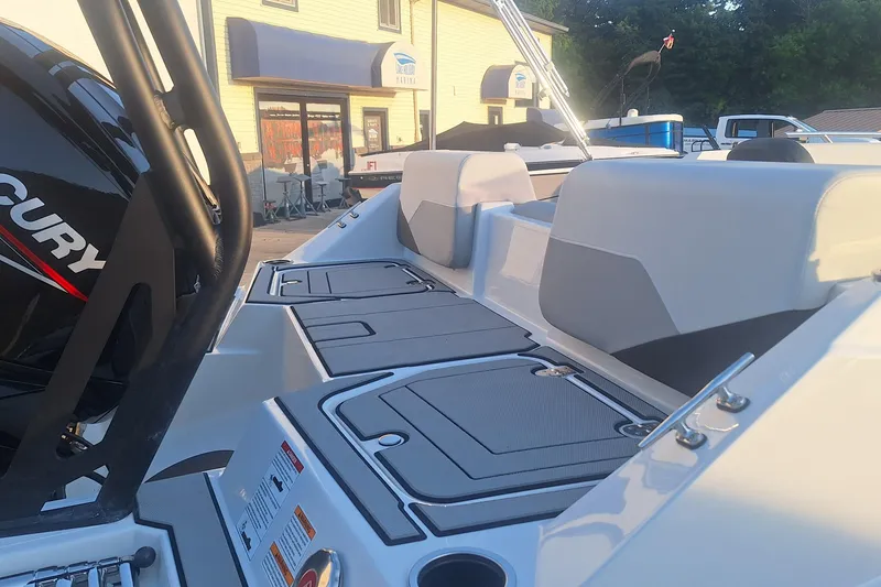 Slide: The Image of 2026 Starcraft SV 16 OB boat interior with Mercury engine, docked near a marina. - 4