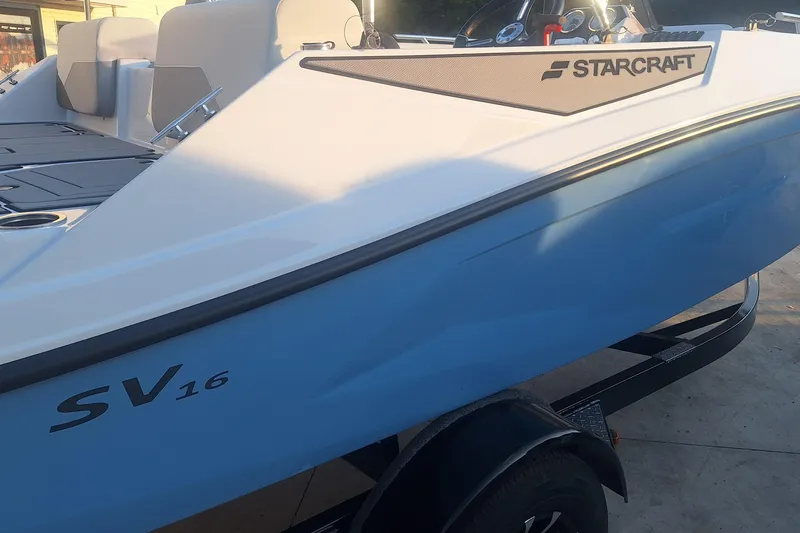 Slide: The Image of 2026 Starcraft SV 16 OB boat, white and blue design, on a trailer. - 5