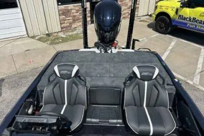 Slide: The Image of 2026 Skeeter ZXE20 boat interior with dual seats and motor, parked outdoors. - 5