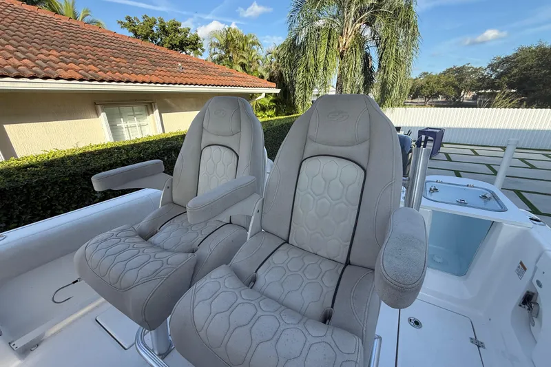 Slide: The Image of 2021 Sea Fox 268 Commander boat seats with armrests, set against a tropical background. - 32