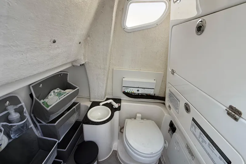 Slide: The Image of 2021 Sea Fox 268 Commander boat bathroom with toilet, sink, and storage compartments. - 38