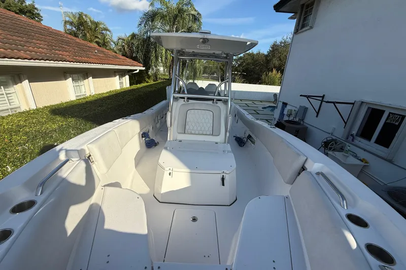 Slide: The Image of 2021 Sea Fox 268 Commander boat interior with seating and console, parked near a house. - 42