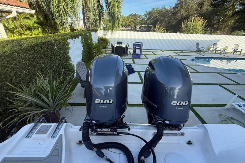 Slide: The Image of Twin Yamaha 200 engines on a 2021 Sea Fox 268 Commander boat, near a poolside. - 55