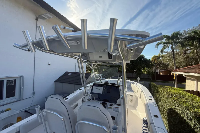 Slide: The Image of 2021 Sea Fox 268 Commander boat with T-top and helm, parked near a house. - 56
