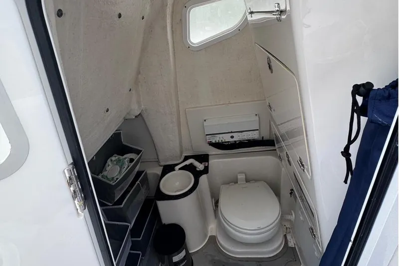 Slide: The Image of 2021 Sea Fox 268 Commander boat interior with compact marine toilet and storage compartments. - 8