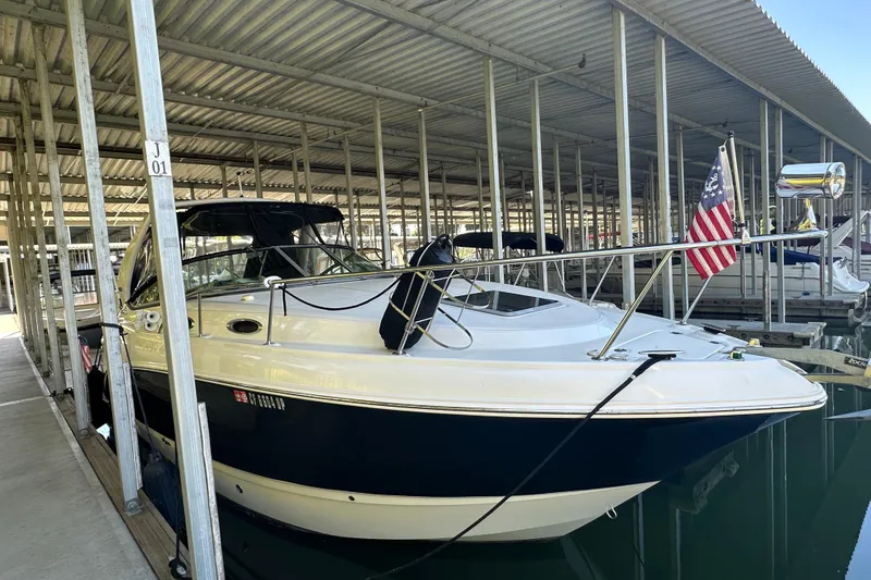 The Image of 2005 Chaparral 270 Signature boat docked in covered marina with American flag. - 0