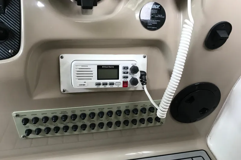 Slide: The Image of Control panel of a 2005 Chaparral 270 Signature boat with VHF radio and switches. - 14