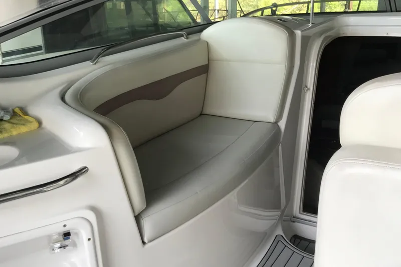 Slide: The Image of Interior seating of 2005 Chaparral 270 Signature boat, featuring white upholstery and sleek design. - 16