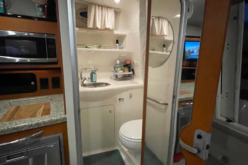 Slide: The Image of 2005 Chaparral 270 Signature boat interior with kitchenette and compact bathroom. - 2