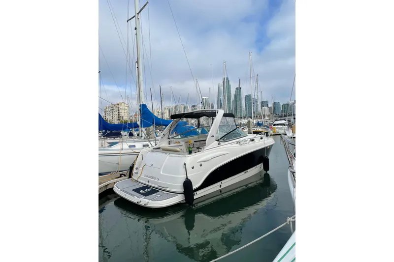Slide: The Image of 2005 Chaparral 270 Signature boat docked in a marina with city skyline. - 22