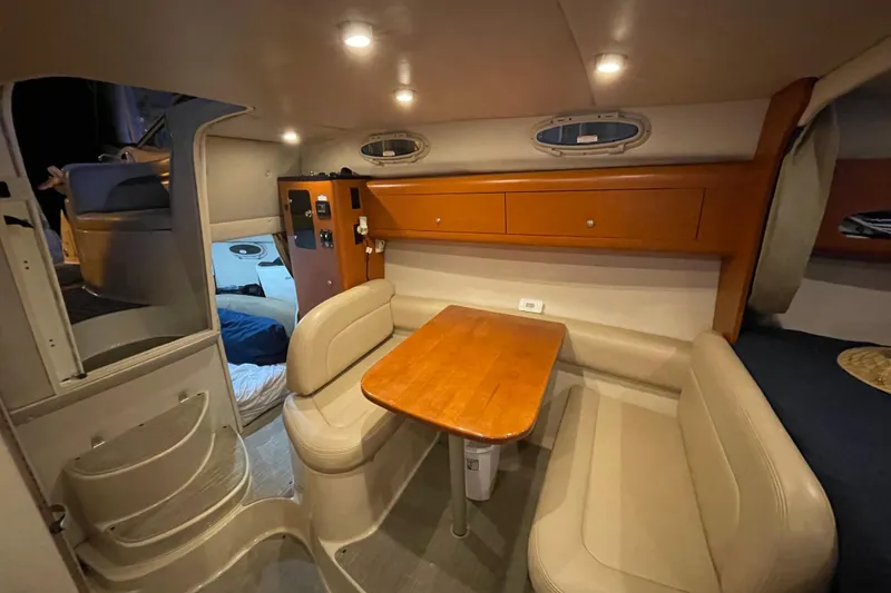 Slide: The Image of 2005 Chaparral 270 Signature cabin interior with cozy seating and wooden table. - 6