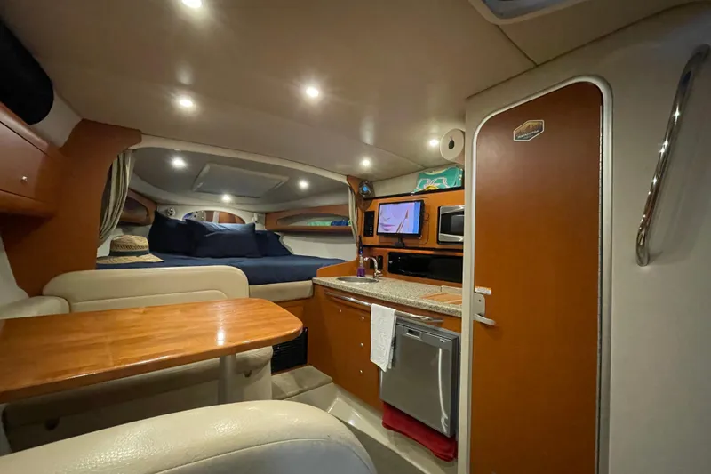Slide: The Image of 2005 Chaparral 270 Signature cabin interior with kitchenette, seating, and sleeping area. - 7