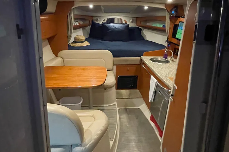 Slide: The Image of 2005 Chaparral 270 Signature cabin interior with bed, kitchenette, and seating area. - 8