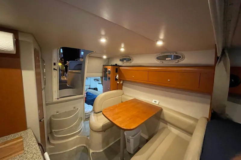 Slide: The Image of 2005 Chaparral 270 Signature cabin interior with seating, table, and storage. - 9