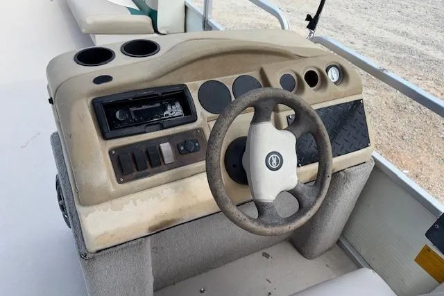 Slide: The Image of 1997 Grumman 24 FS boat dashboard with steering wheel and control panel. - 11