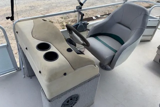 Slide: The Image of 1997 Grumman 24 FS boat cockpit with steering wheel and cushioned seat. - 14