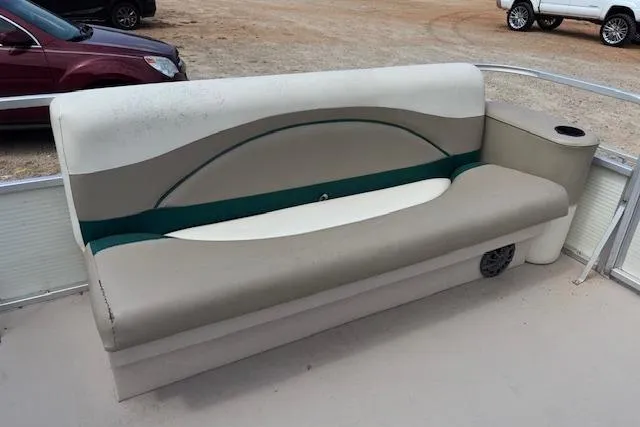 Slide: The Image of 1997 Grumman 24 FS boat seat with beige and green upholstery on deck. - 16