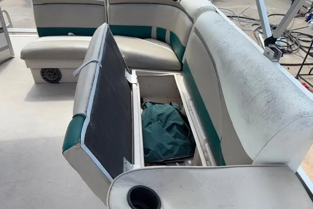 Slide: The Image of 1997 Grumman 24 FS boat interior with open storage compartment and seating. - 18
