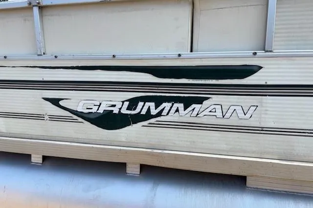 Slide: The Image of 1997 Grumman 24 FS boat side view with logo and design details. - 19