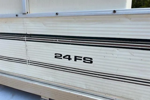 Slide: The Image of 1997 Grumman 24 FS boat side view with model name and stripes. - 20