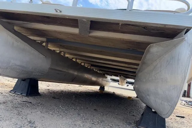 Slide: The Image of Underneath view of a 1997 Grumman 24 FS pontoon boat on stands. - 21