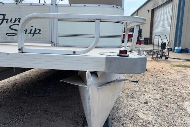 Slide: The Image of 1997 Grumman 24 FS pontoon boat with visible damage on the front corner. - 22