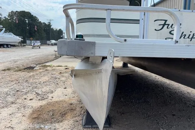 Slide: The Image of 1997 Grumman 24 FS pontoon boat on dry land, side view. - 23