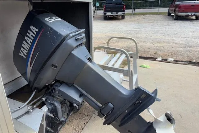 Slide: The Image of Outboard Yamaha motor on a 1997 Grumman 24 FS boat, parked on concrete. - 5