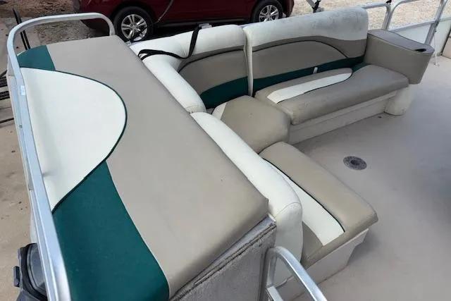 Slide: The Image of Interior seating of a 1997 Grumman 24 FS boat with beige and green upholstery. - 8