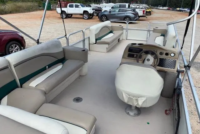 Slide: The Image of 1997 Grumman 24 FS pontoon boat interior with beige seating and steering console. - 9