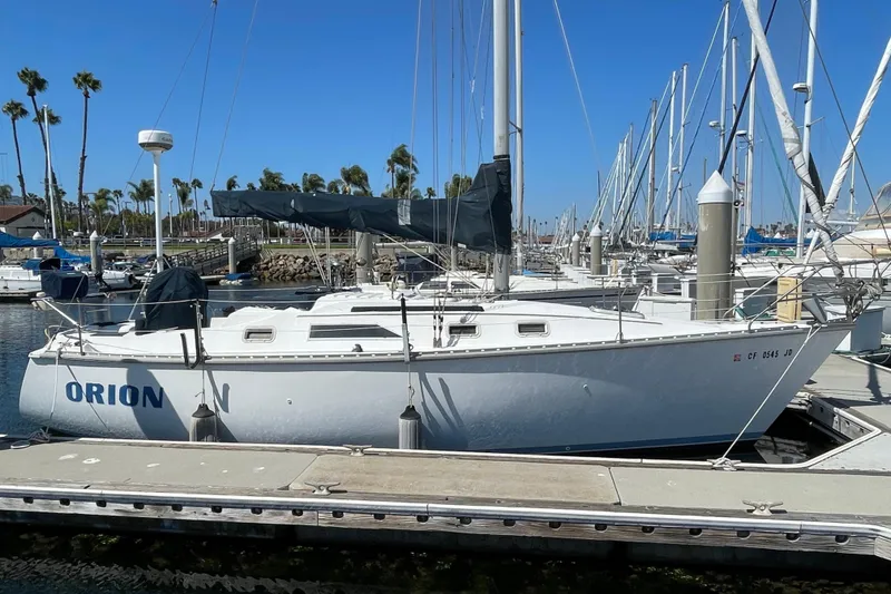 Slide: The Image of 1985 Hunter 31 sailboat docked at marina with clear blue sky. - 1